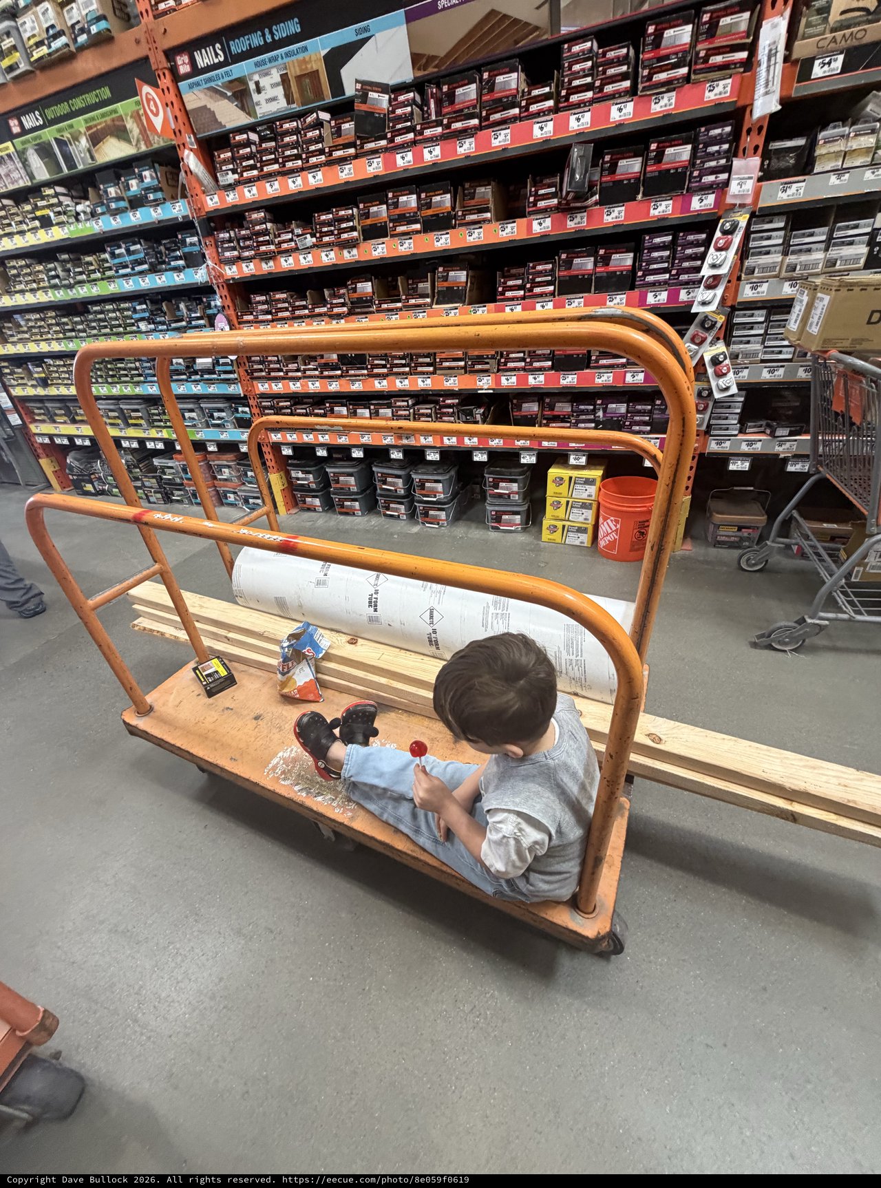 Child Riding Home Depot Lumber Cart in Hardware Aisle