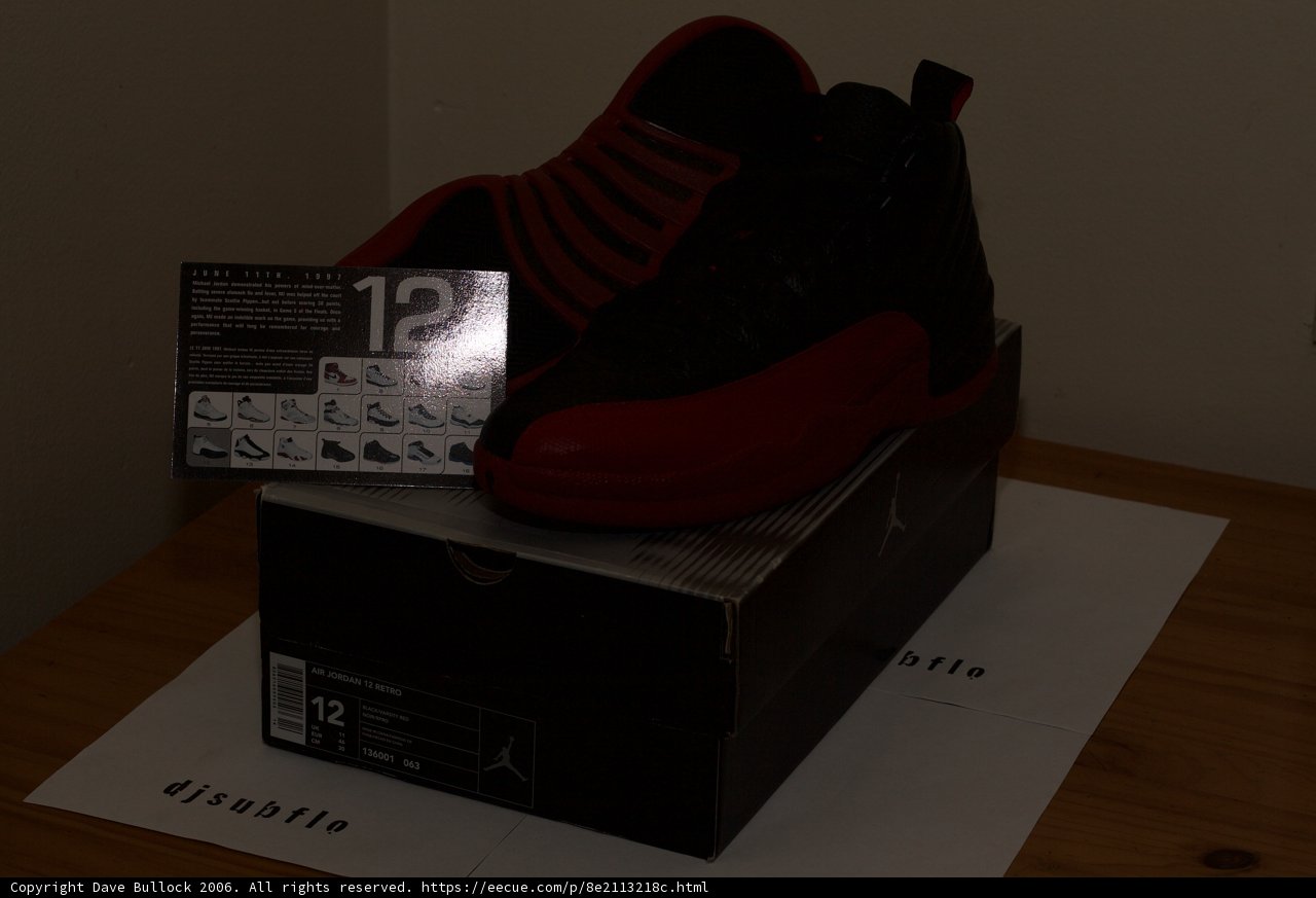 Black and Red Sneakers Against Hardwood Flooring