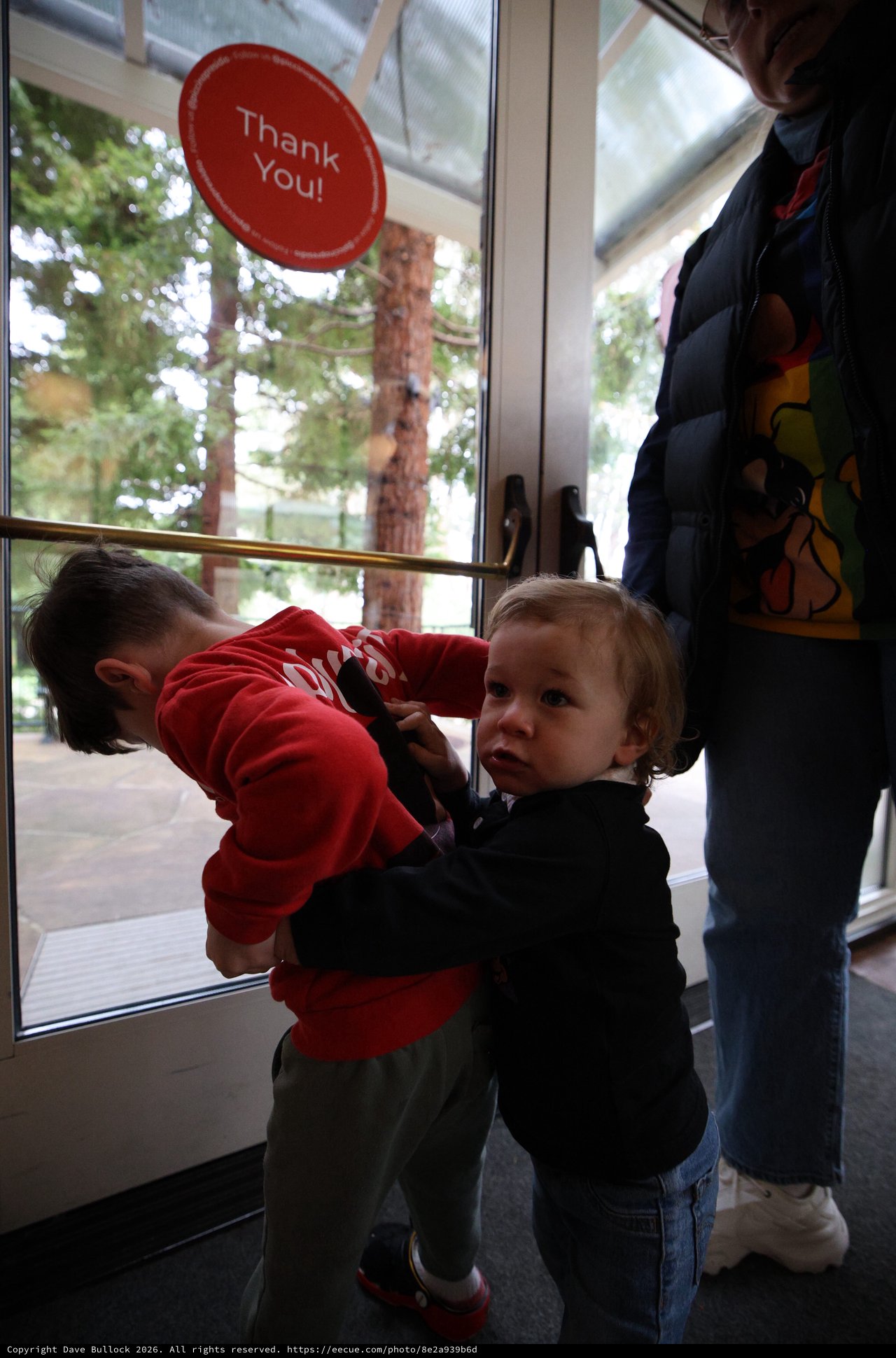 Two Young Children Playing by Glass Door