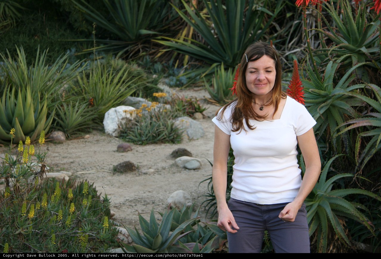 Woman Smiling Among Desert Succulents and Aloe