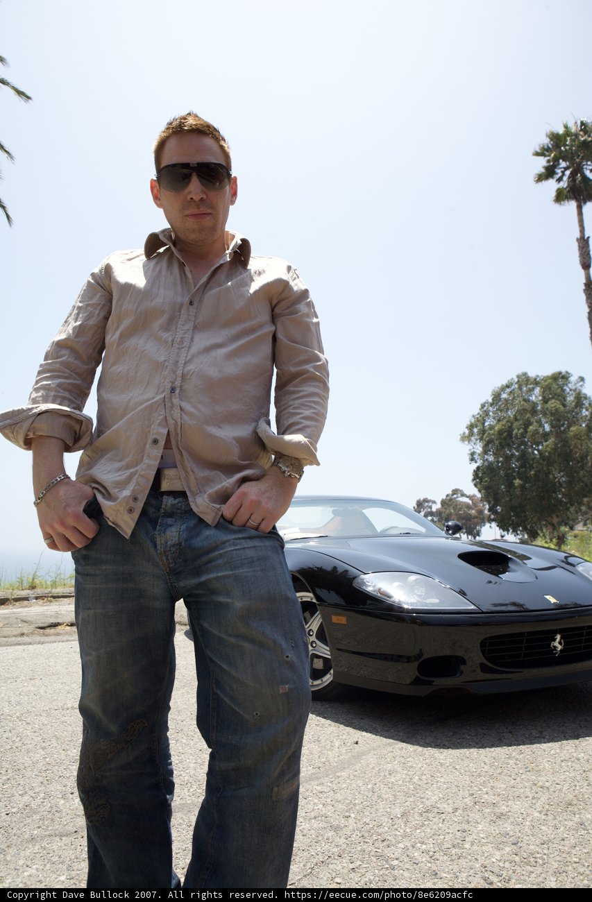 Man posing next to shiny sports car