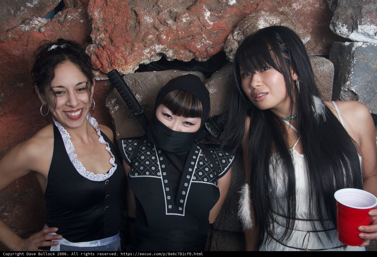Three Women in Costumes Celebrate Halloween at a Urban Club