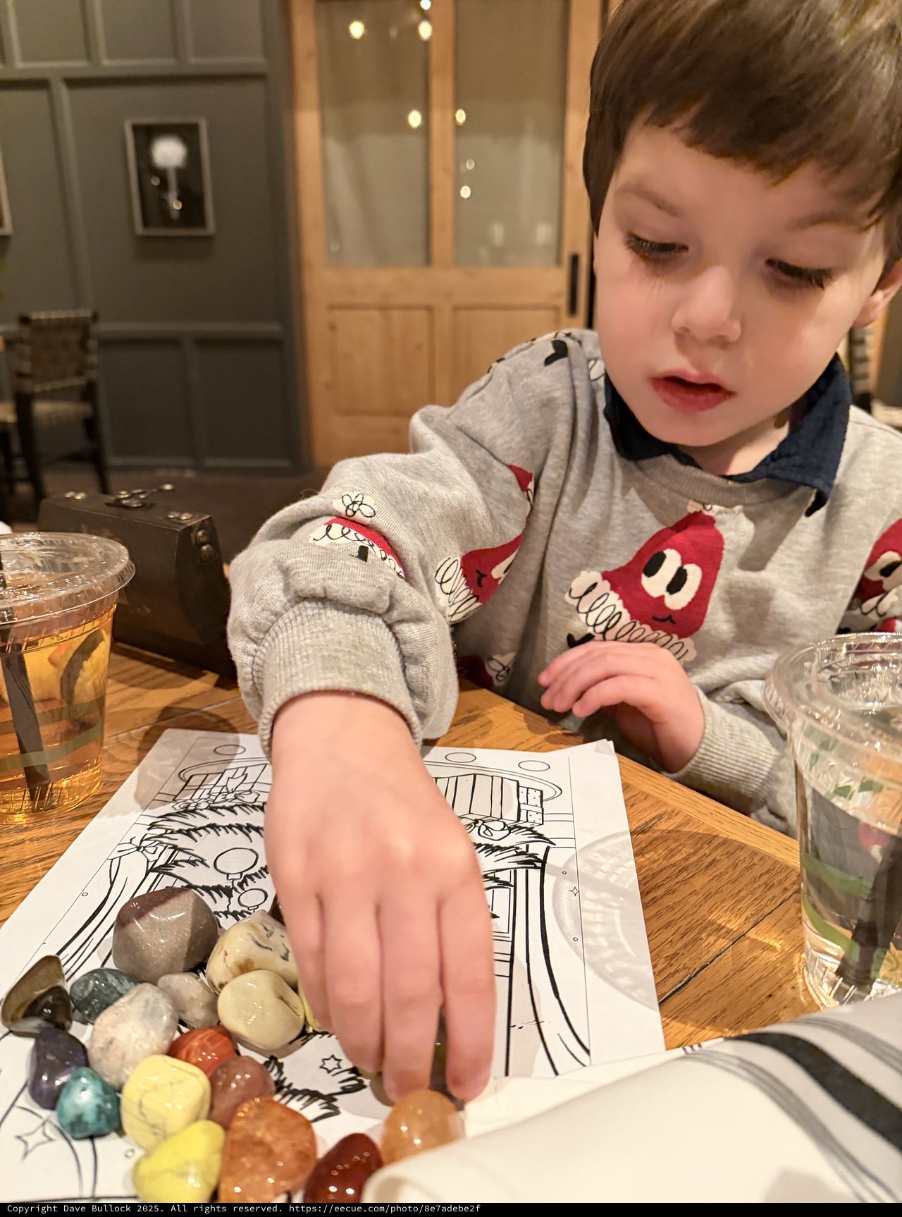 Young Boy Exploring Colorful Gemstones at Restaurant Table