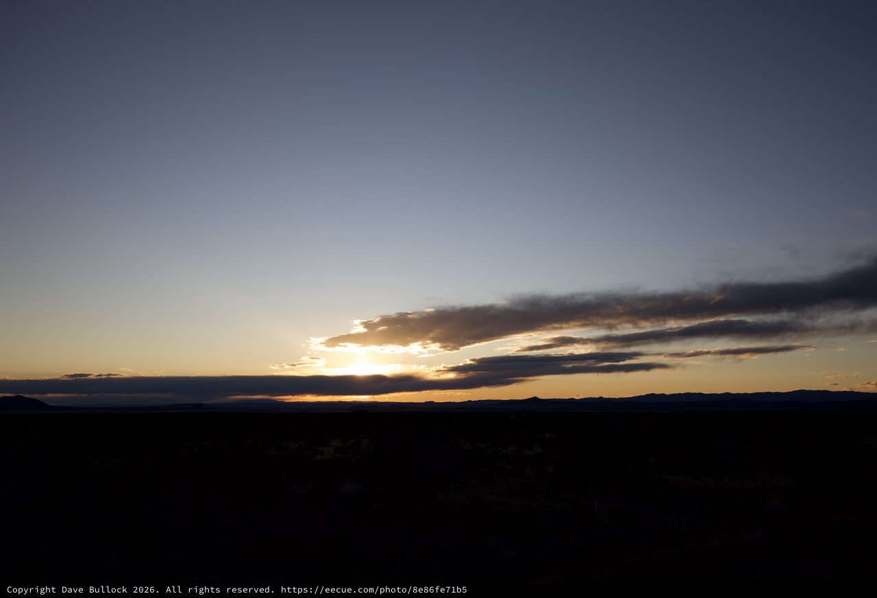 Dramatic Desert Sunset Over Distant Mountain Range