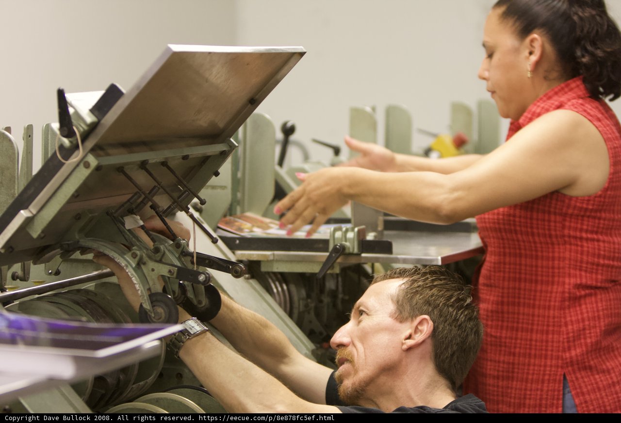 Two Adults Working Out on a Leg Press Machine in a Health Club