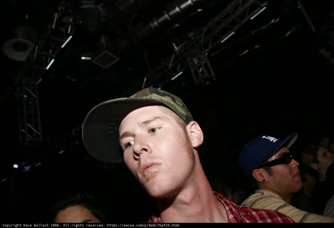 Man in Plaid Shirt Wearing Two Hats