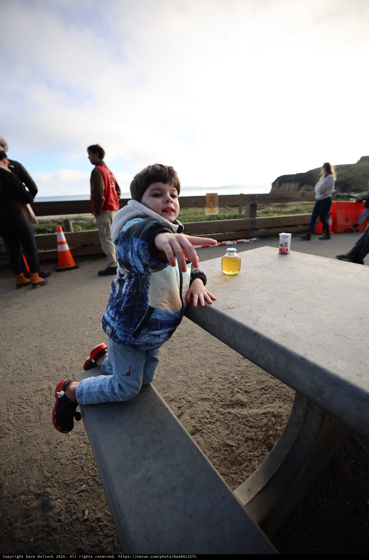 Young Boy Playing on Concrete Bench at Coastal Park