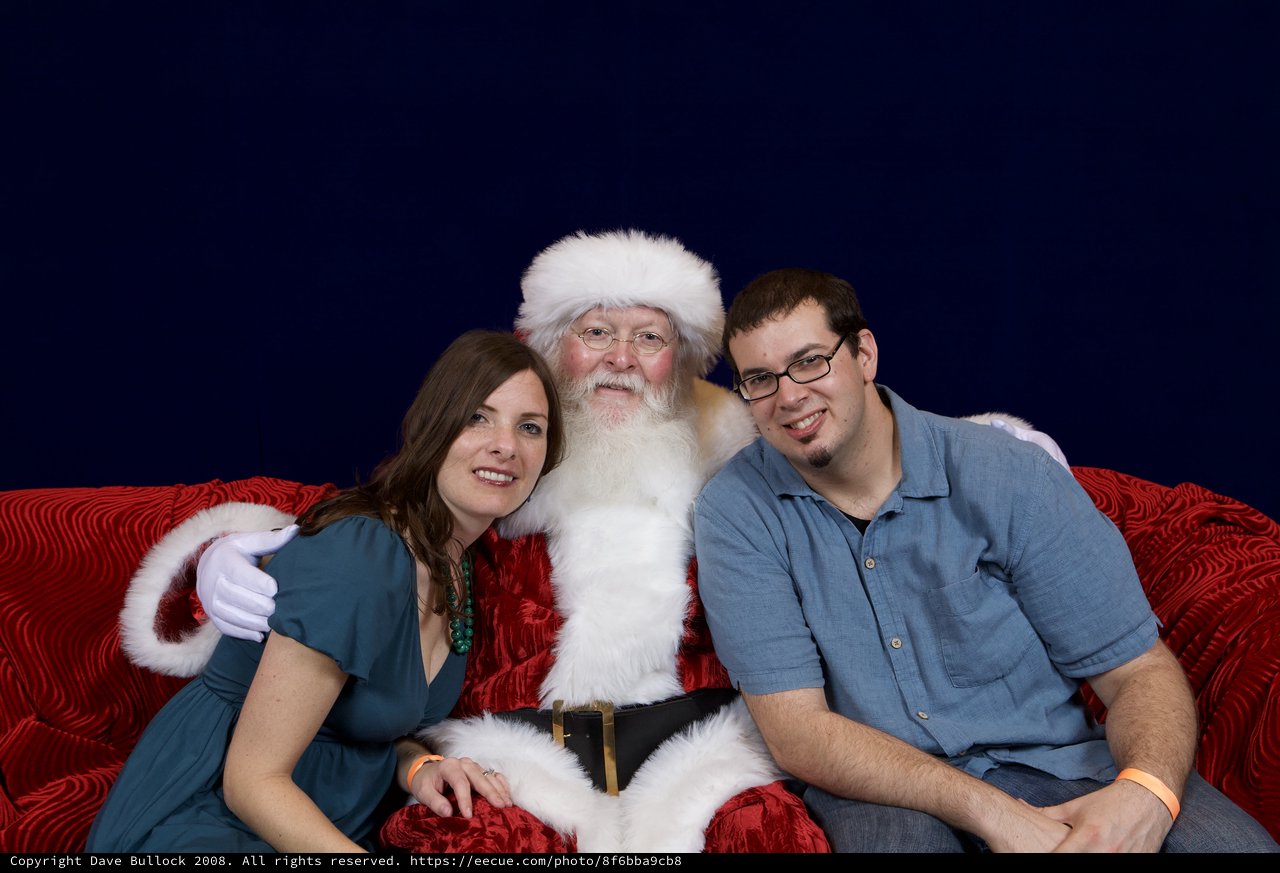 Couple Poses with Santa at Christmas Party