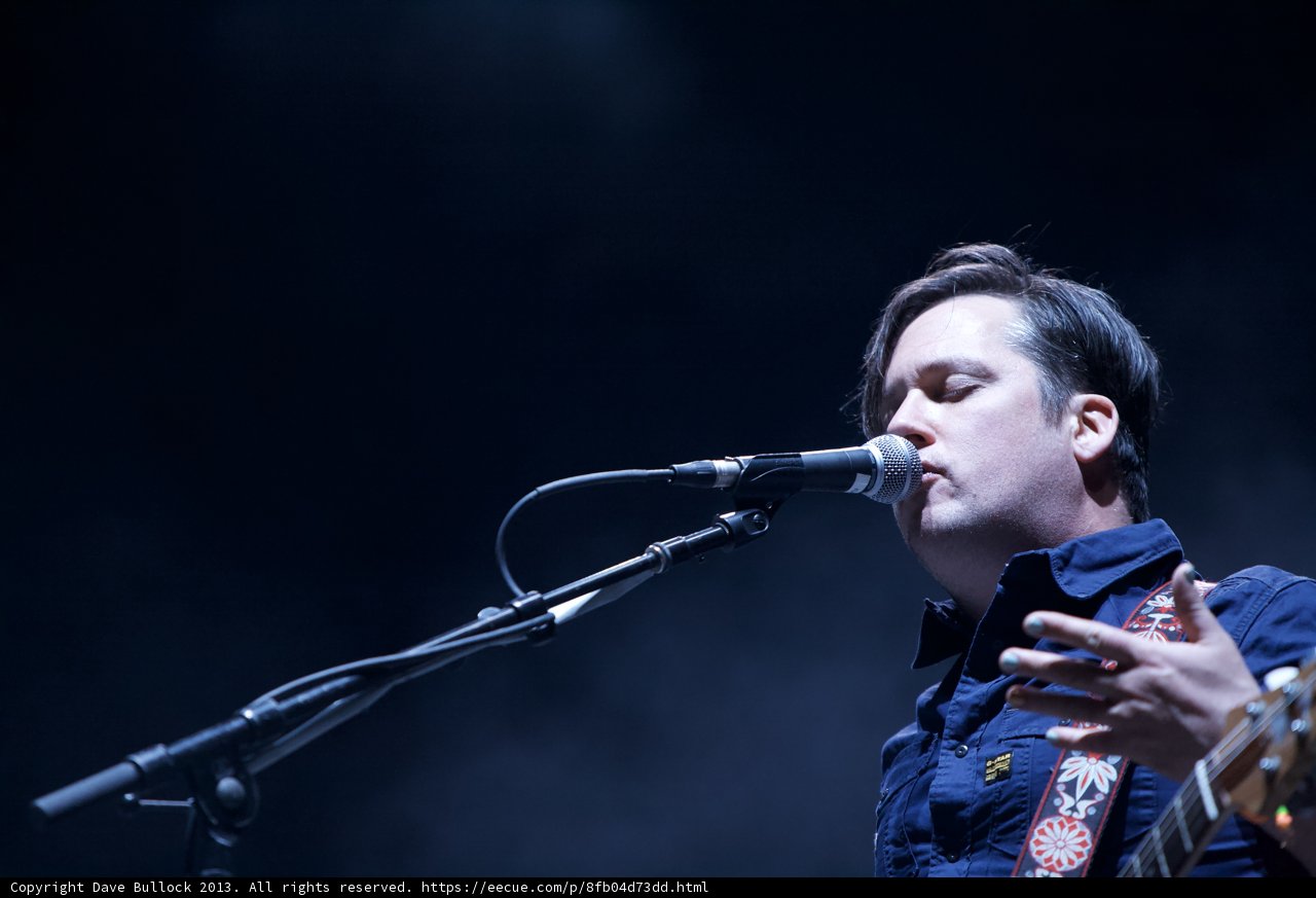 Blue Shirted Musician Strums His Guitar