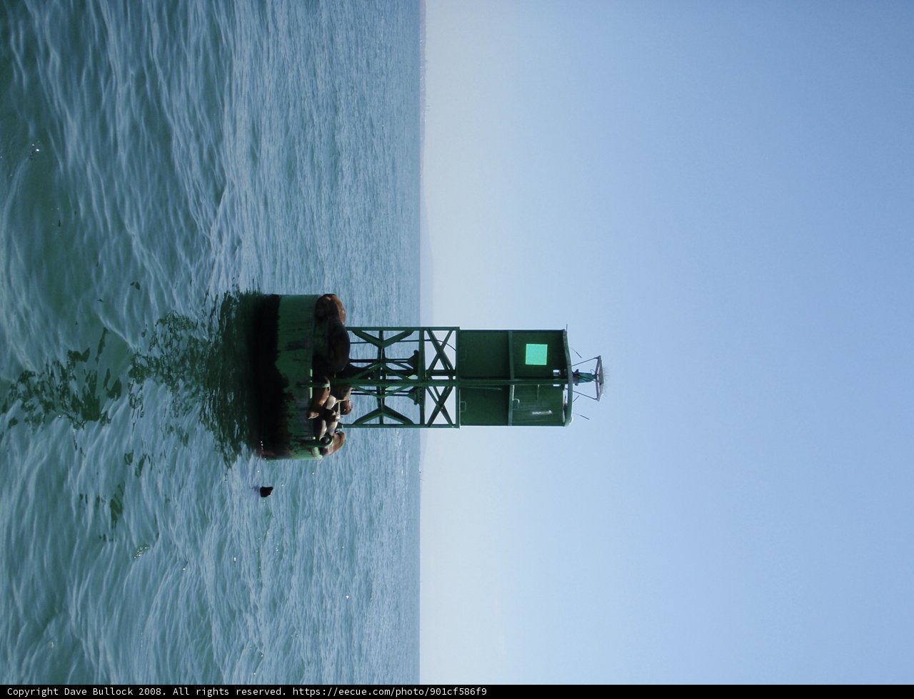 Green Light House in the Middle of the Ocean