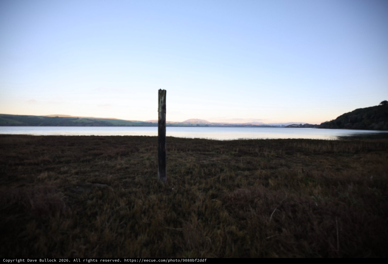 Solitary Wooden Post at Twilight Coastal Shore