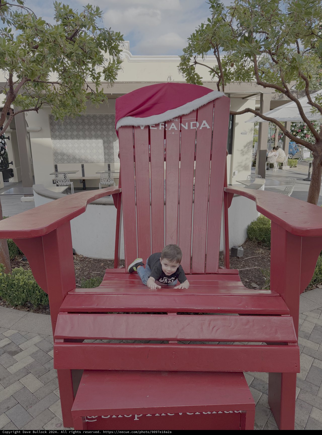 Child Playing in Oversized Red Adirondack Chair