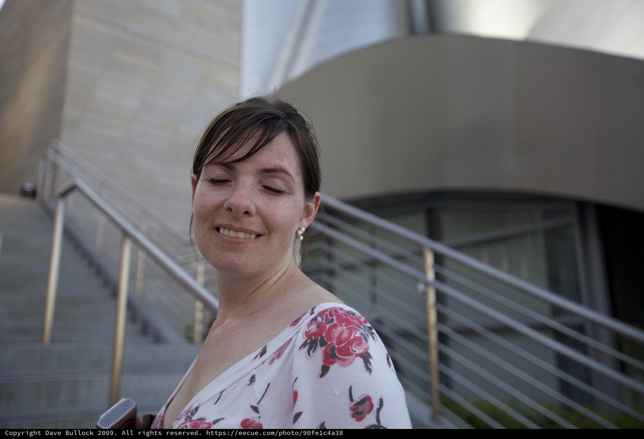 Serene Woman Smiling Outside Modern Architecture