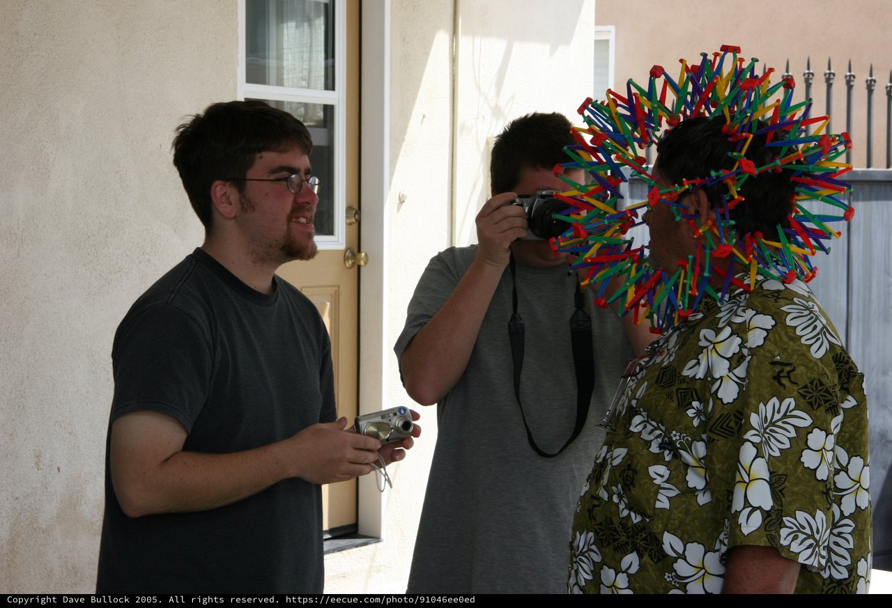 Friends Photograph Man Wearing Colorful Straw Toy Hat