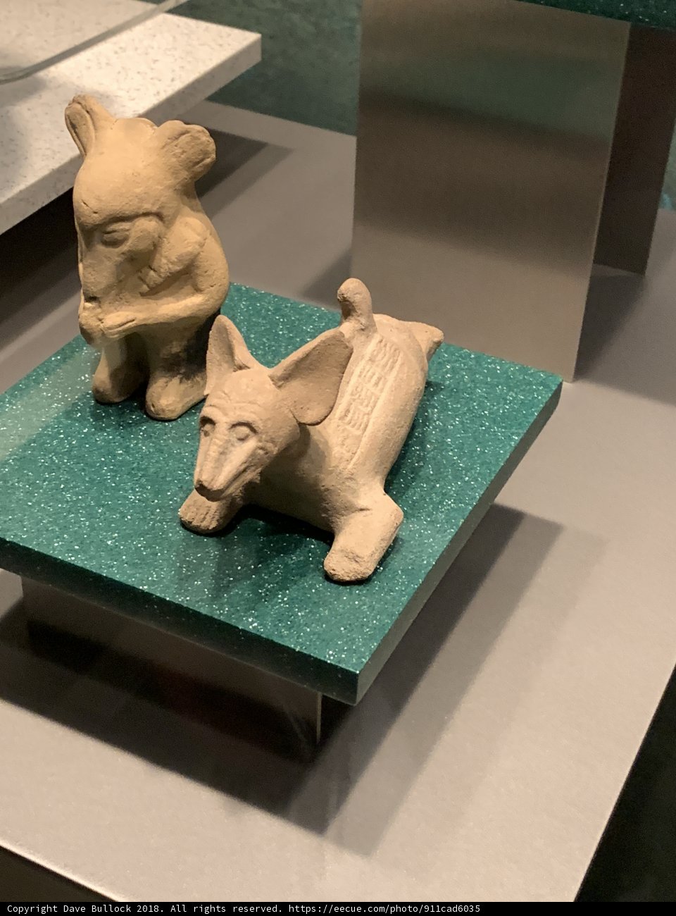 Ancient clay figurines on a green surface
