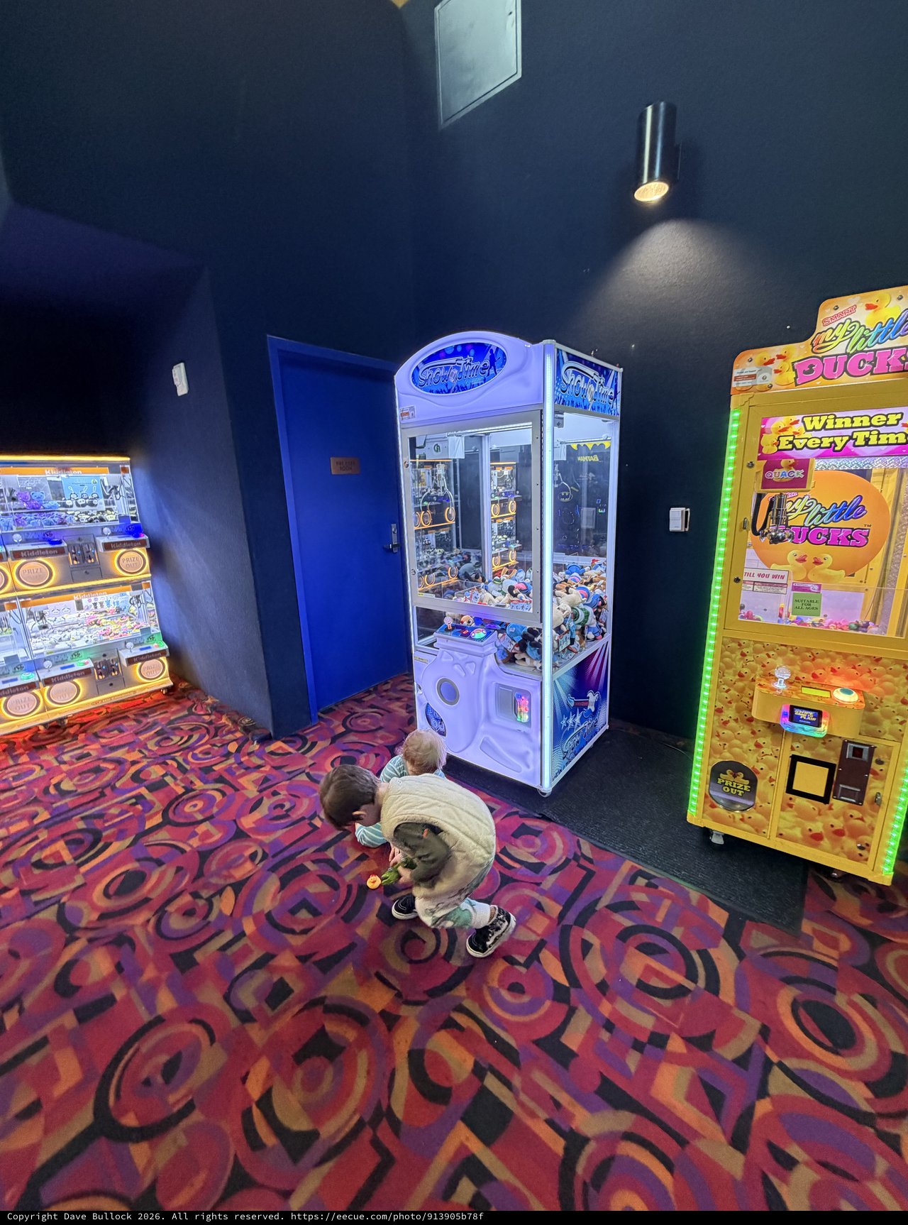 Children Playing Arcade Claw Machines at Entertainment Venue