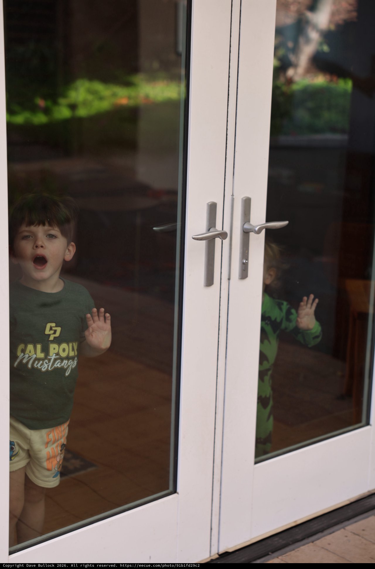 Young Boy Locked Outside Behind Glass Door
