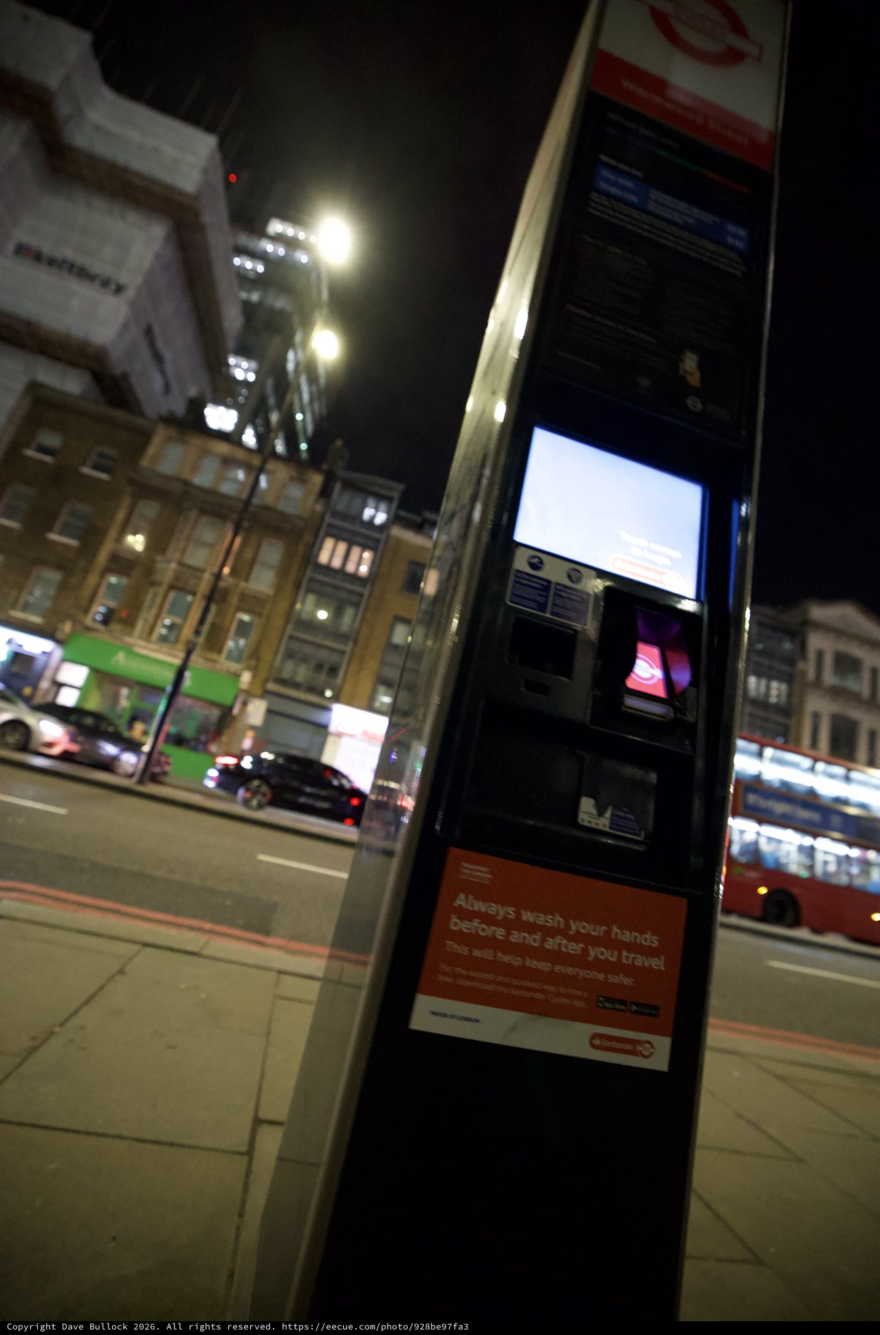 Night Scene at London Bus Stop with Health Advisory