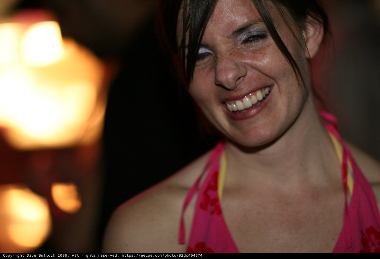 Laughing Woman in Pink at a Nighttime Gathering