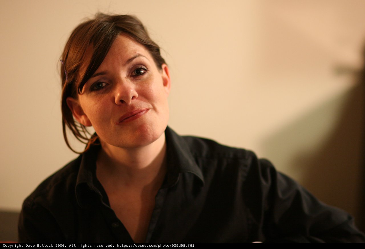 Thoughtful Woman in Black at Indoor Gathering