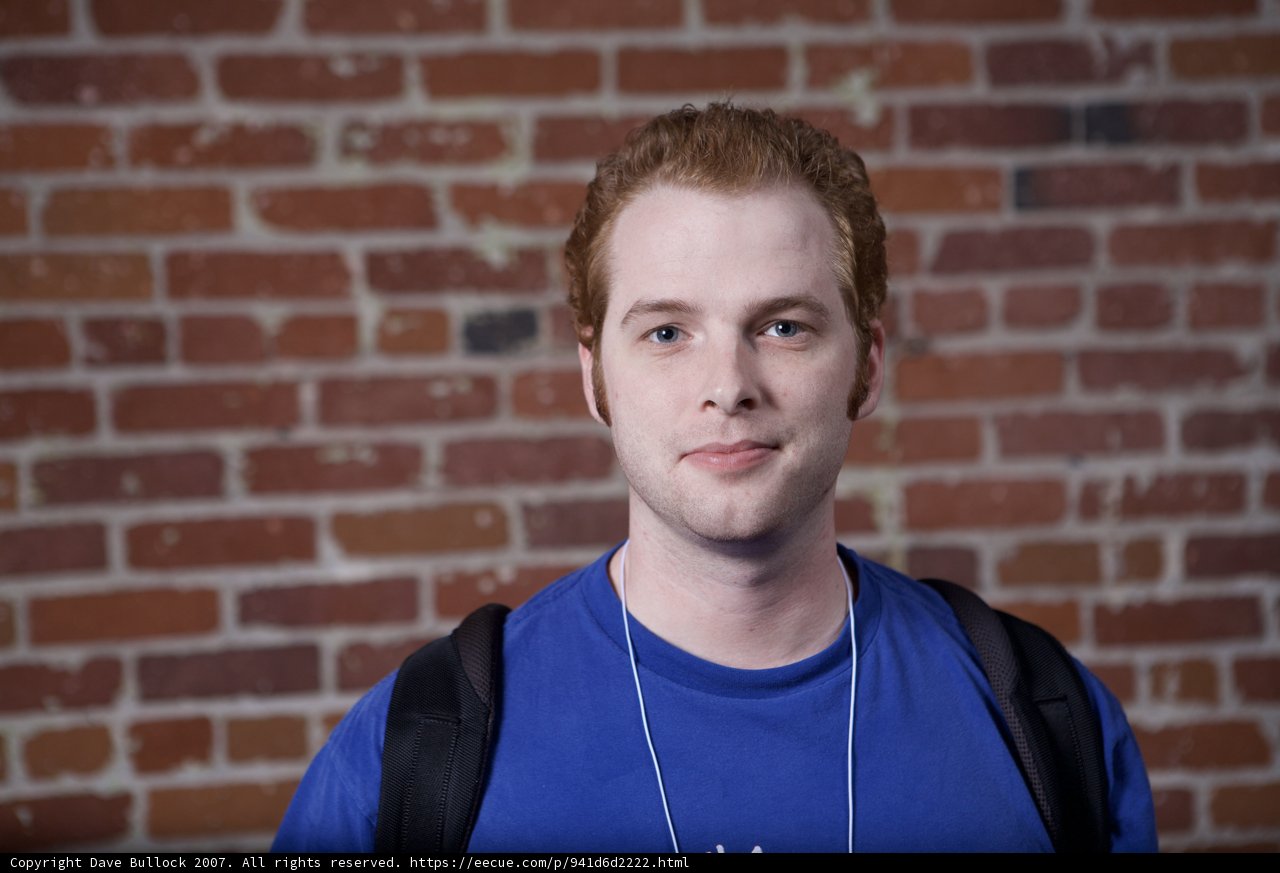 Smiling Man in Blue Shirt with Backpack