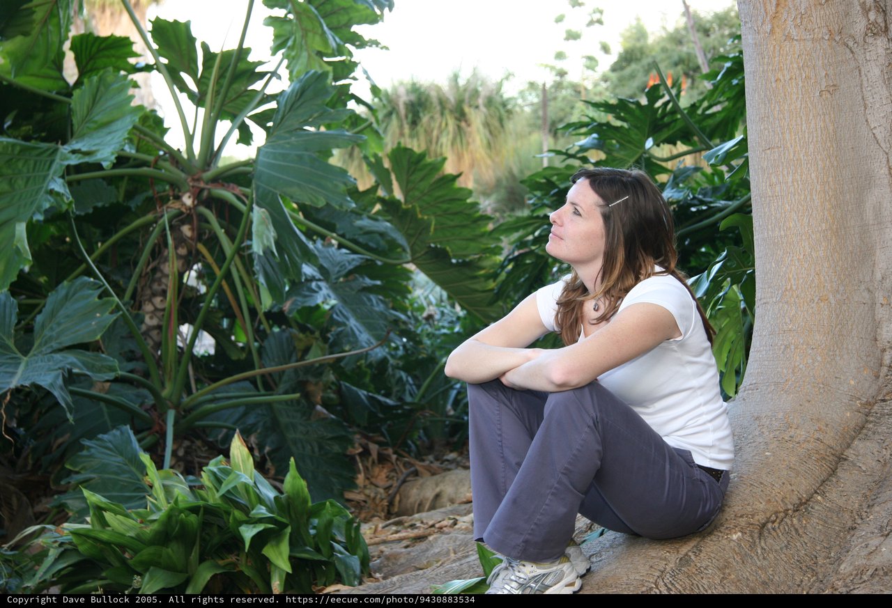 Contemplative Woman Resting Among Tropical Foliage