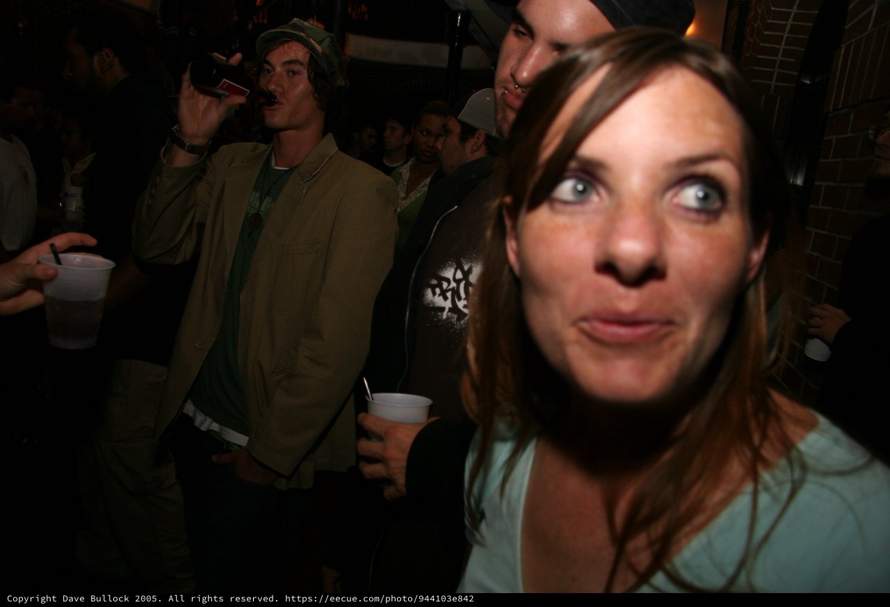 Wide-Eyed Woman at a Crowded Nightclub Party