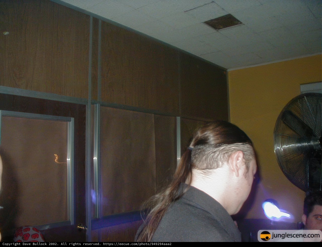 Ponytailed Man Peeking Out from Closet