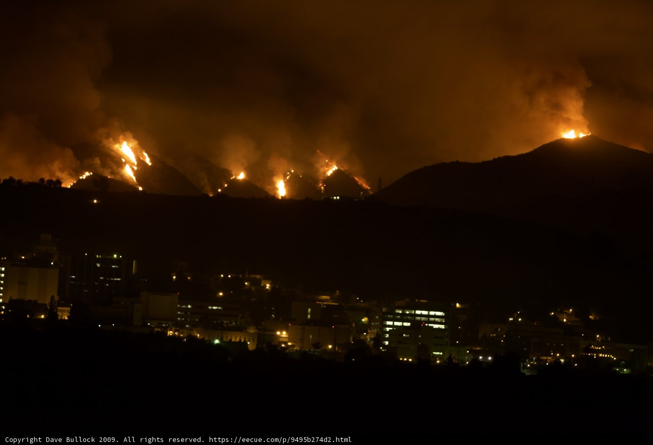 Flames Engulf Cityscape and Mountain Landscape