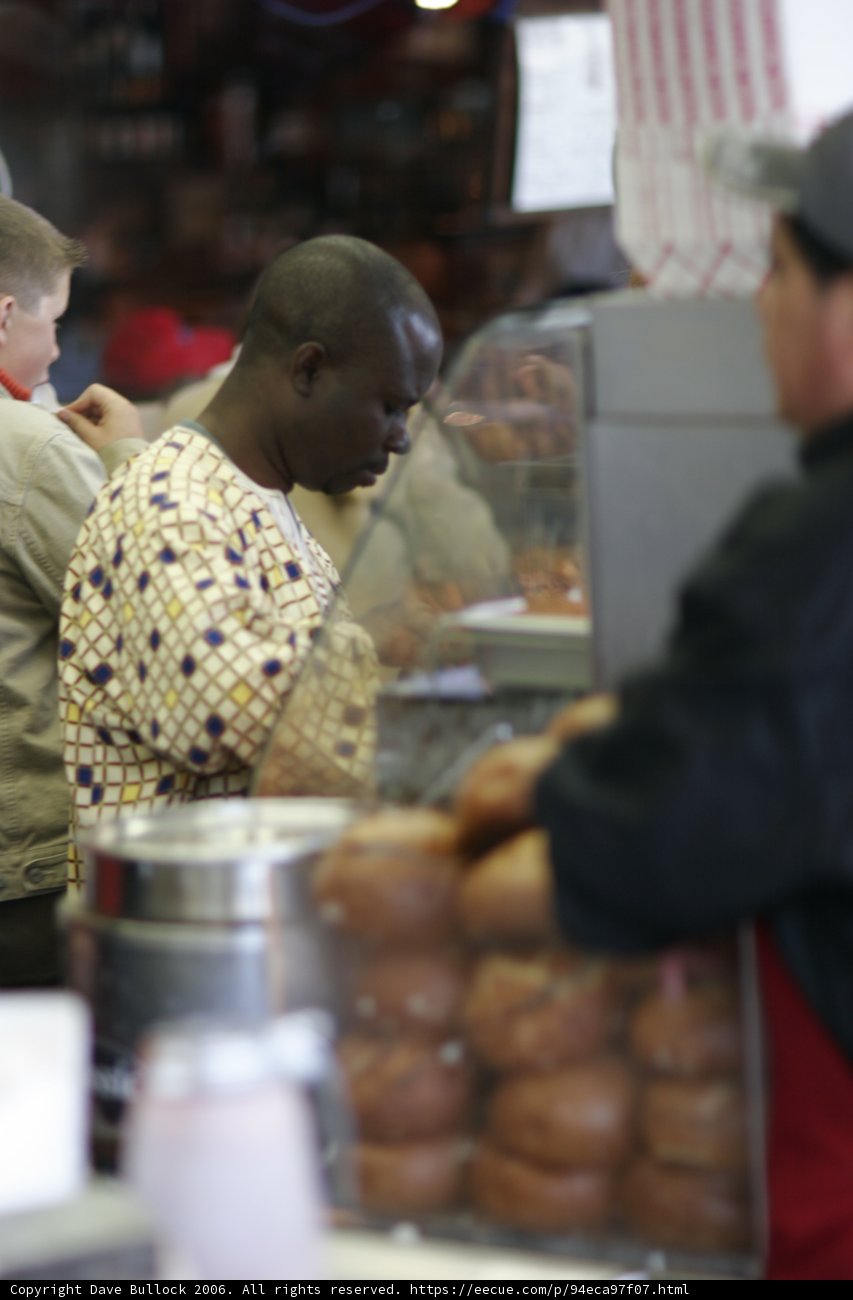 Man in Black Jacket at Bread Shop