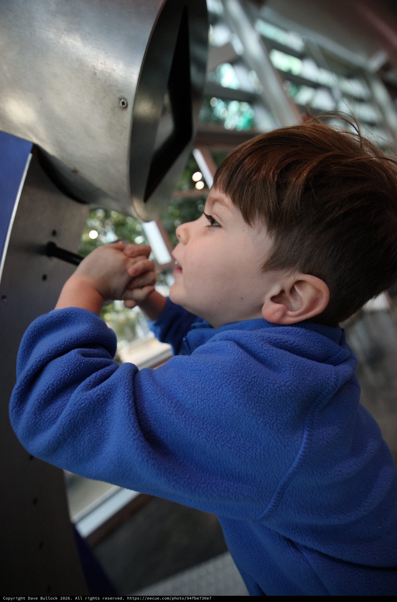 Young Boy Exploring Interactive Exhibit at Science Center