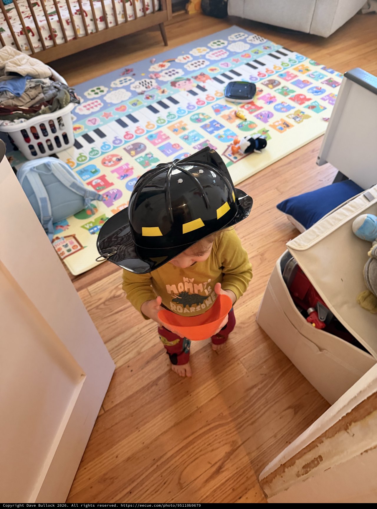 Toddler Playing Firefighter at Home with Toy Helmet
