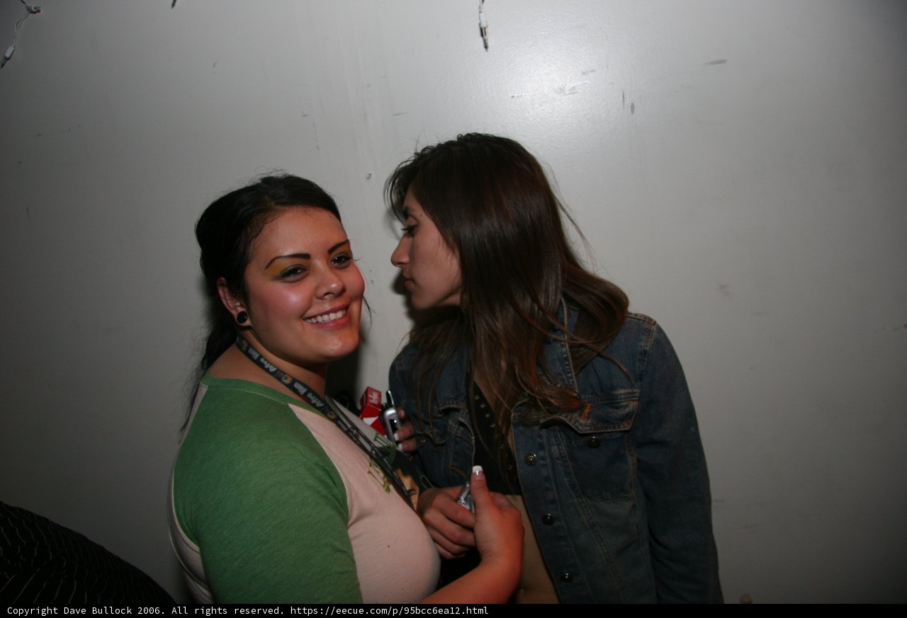 New Year's Eve Kiss Caption: Two women embrace in a loving New Year's Eve kiss, their fingers intertwined and smiles on their faces as they celebrate together.
