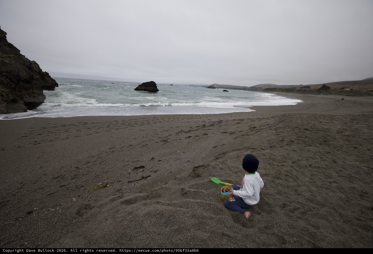 Child Playing Alone on a Rugged Coastal Beach