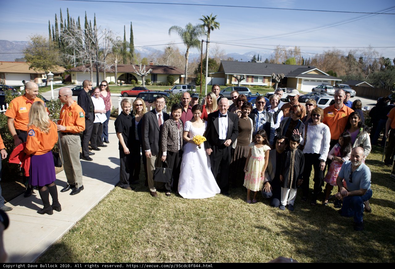 Wedding Party Stands Together in Front of Beautiful Home