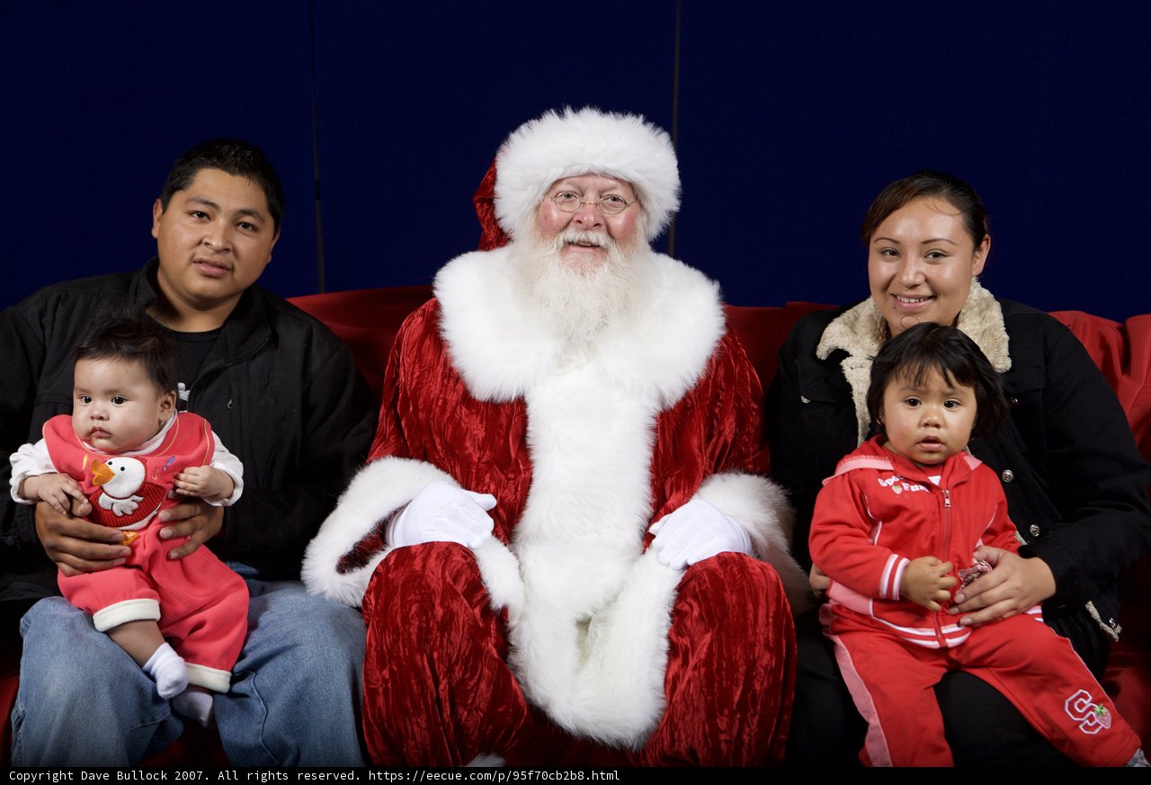 Christmas Cheer: Smiling Family Poses with Santa Claus