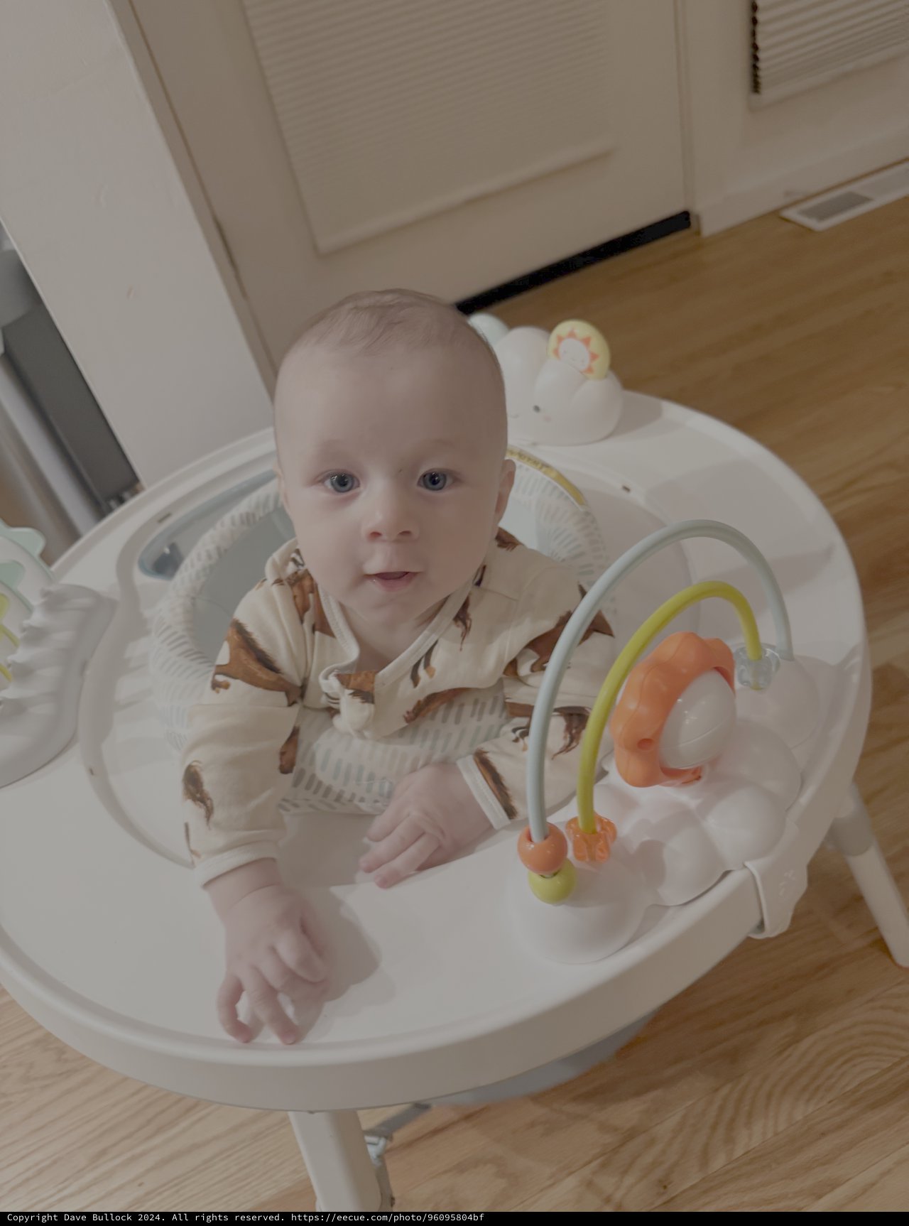 Baby in White Bouncy Seat with Toys