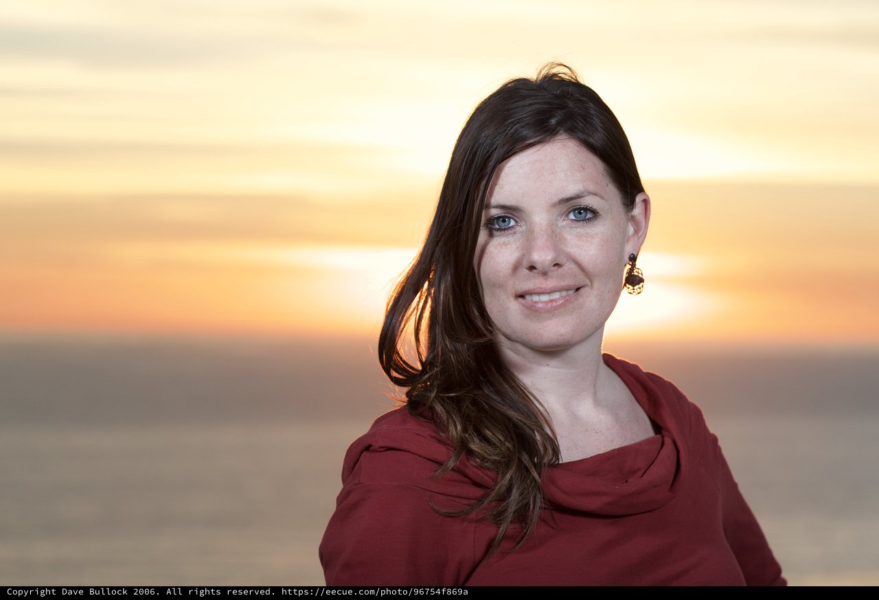 Woman Smiling at Golden Sunset Over Water