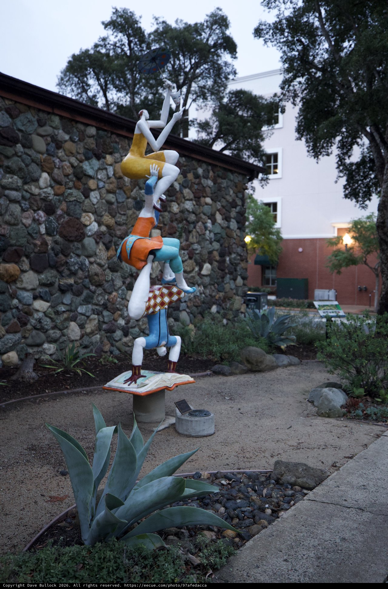 Whimsical Acrobatic Sculpture in Garden Setting at Dusk