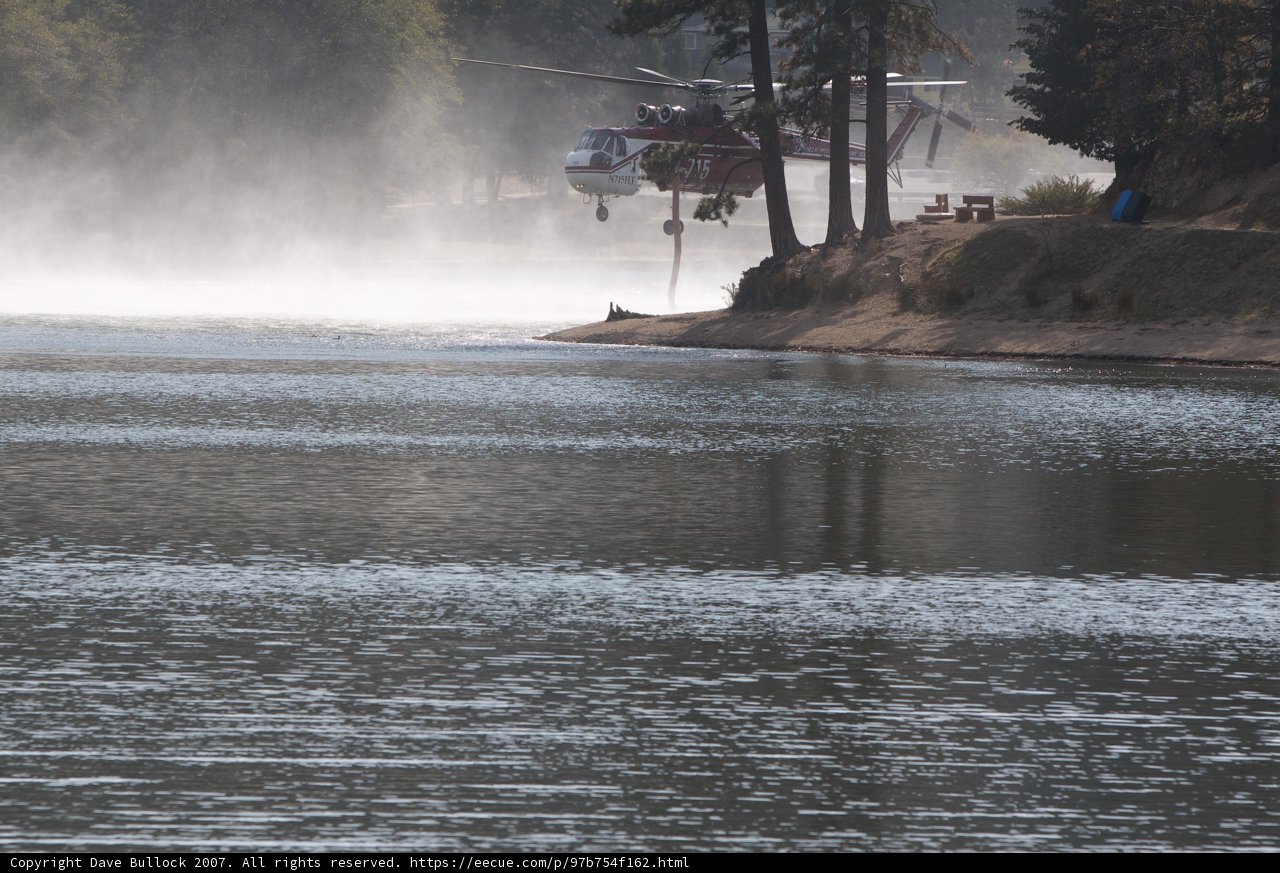 Helicopter Fighting Wildfire by Spraying Water onto Lake