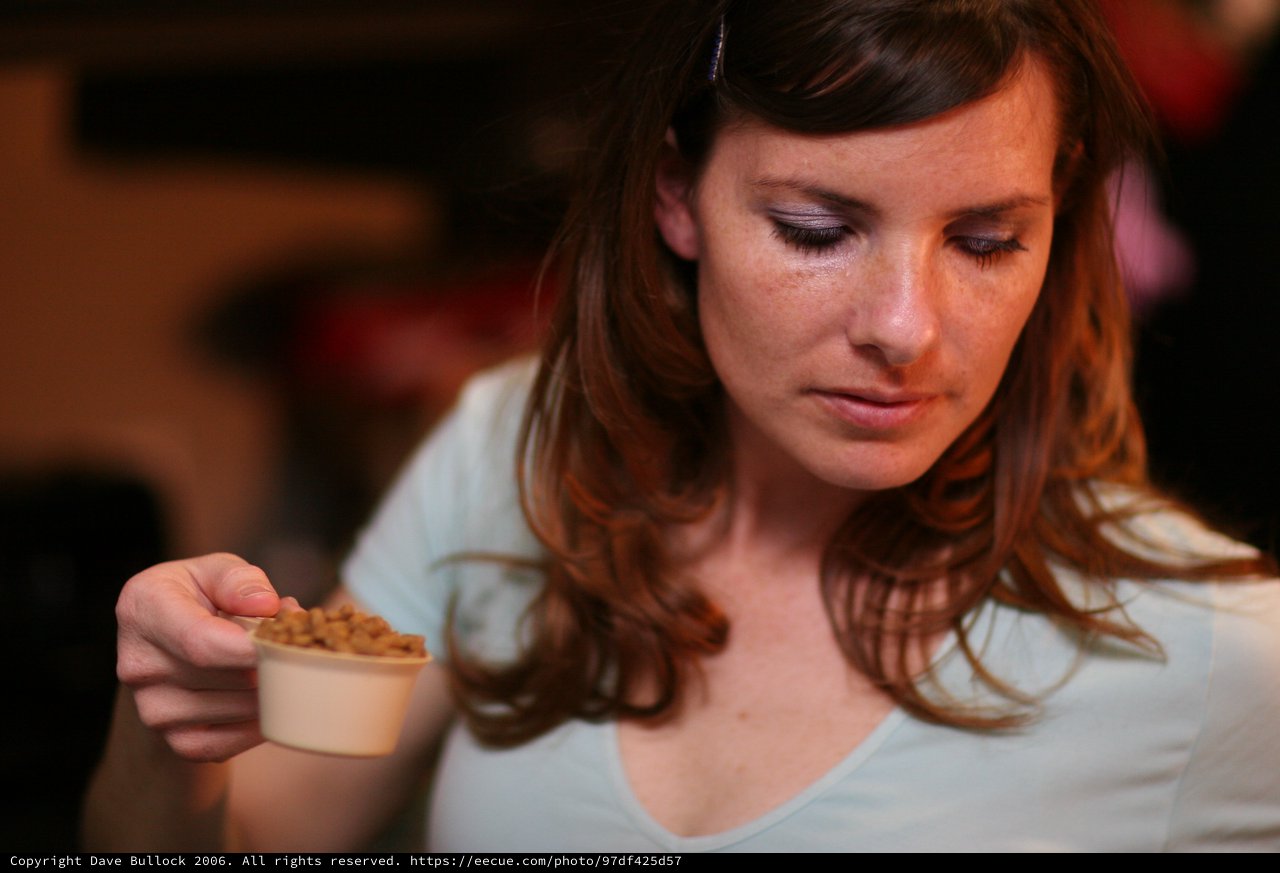 Woman Contemplating Small Cup of Food Sample