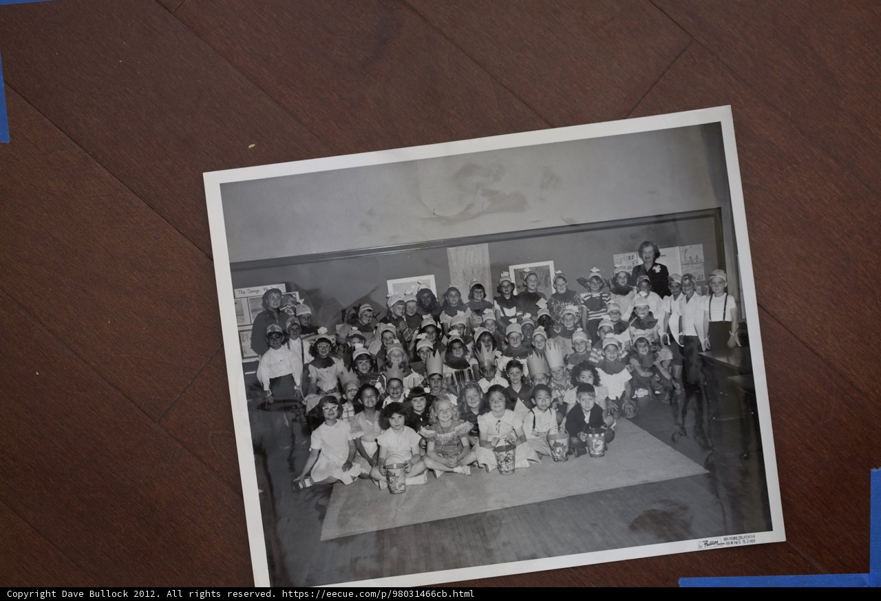 A Crowd of People Sitting on the Hardwood Floor