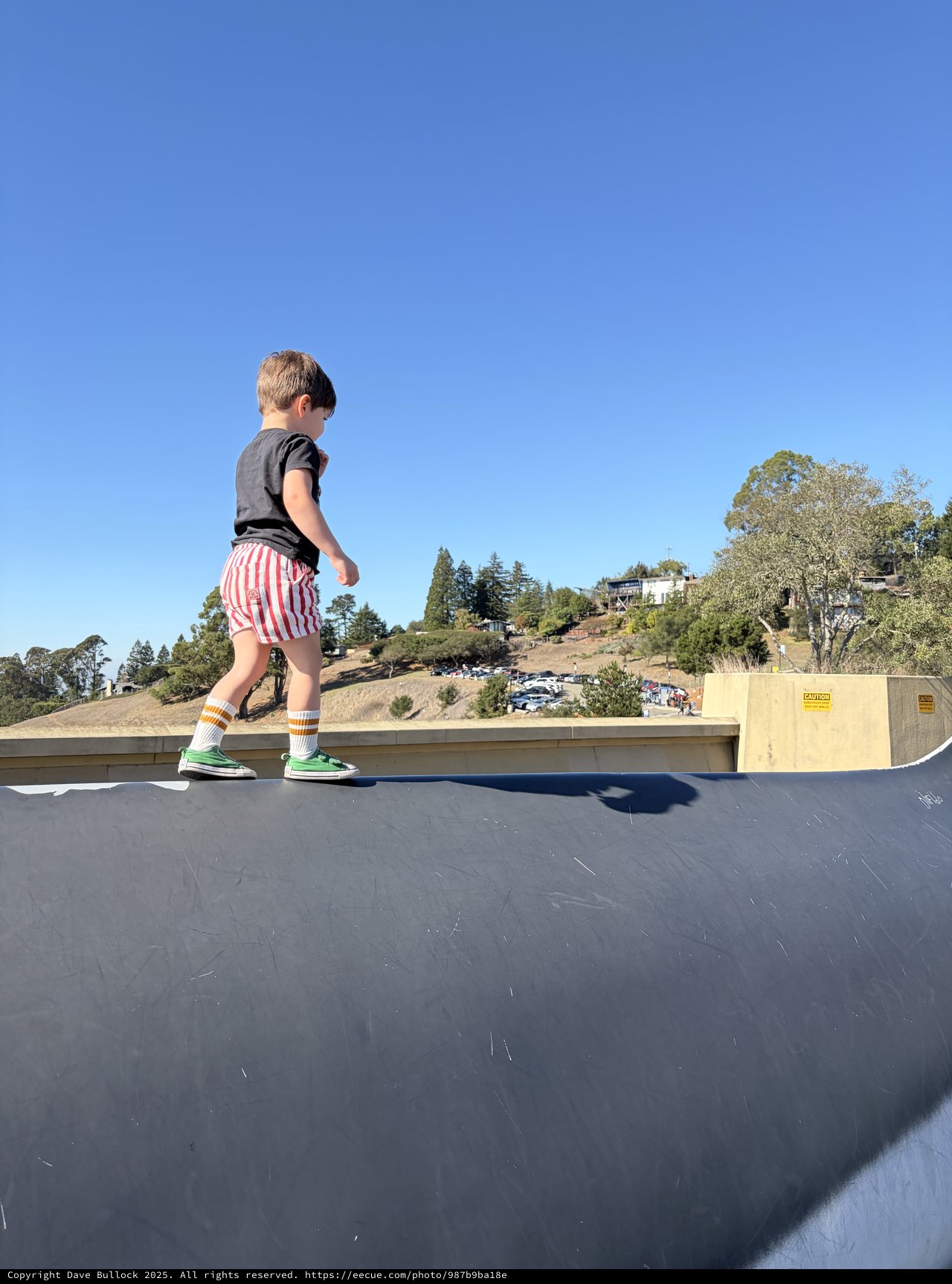 Young Boy Walking on Rooftop Edge at Skate Park