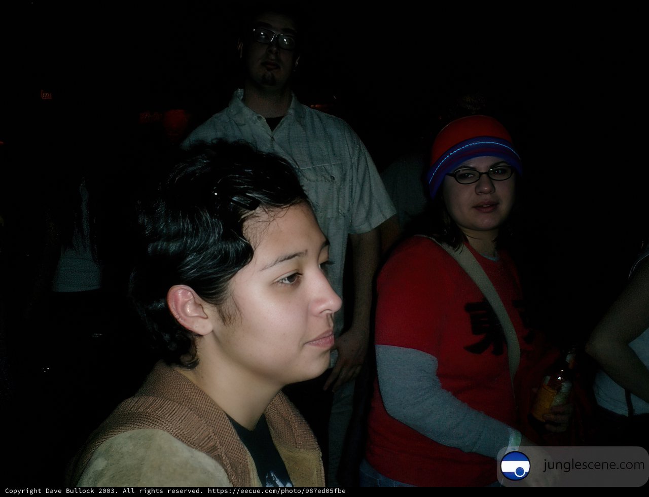 Woman with Hat and Glasses in Front of Crowd
