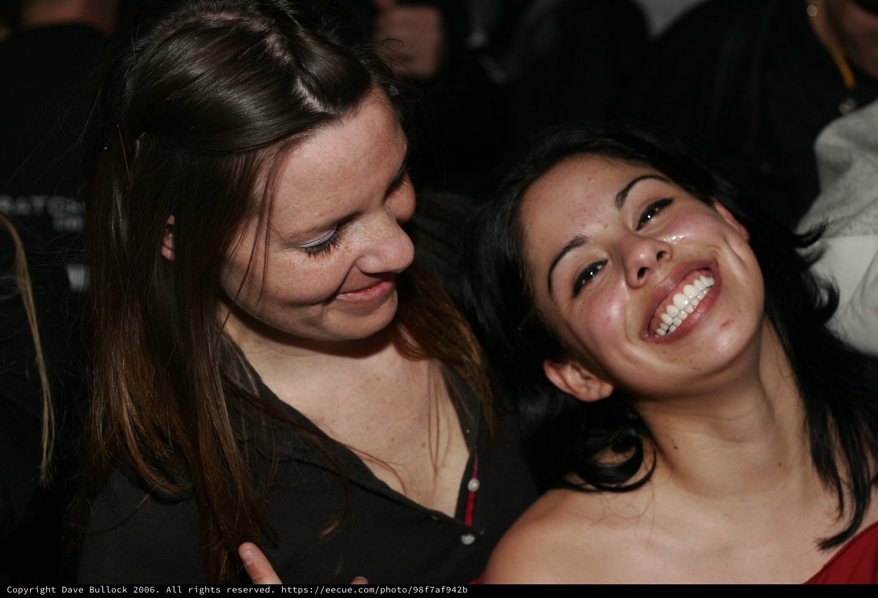 Two Women Laughing Together at Nighttime Event