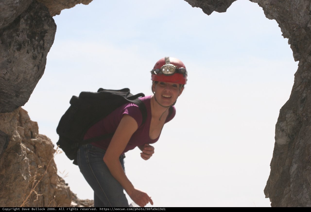 Adventurer Emerges Through Rocky Cave Opening
