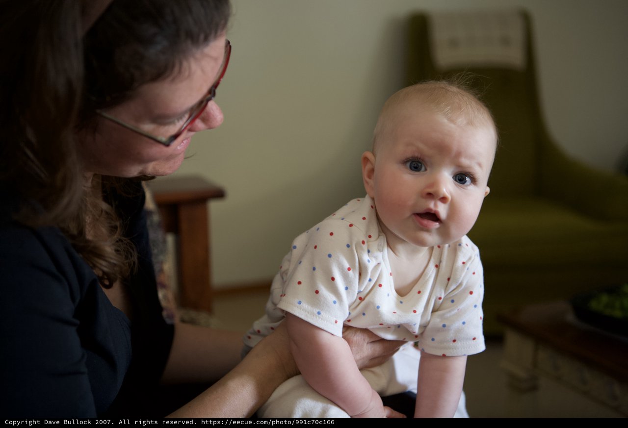 Curious Baby Gazes Forward in Parent's Arms