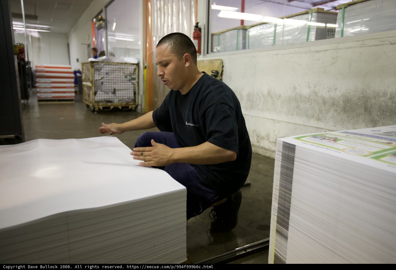 At Work, Making a Mark on a Stack of Plywood Boards