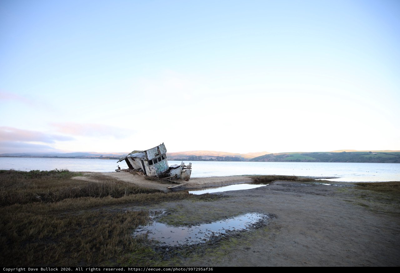 Abandoned Shipwreck at Twilight on Coastal Mudflats