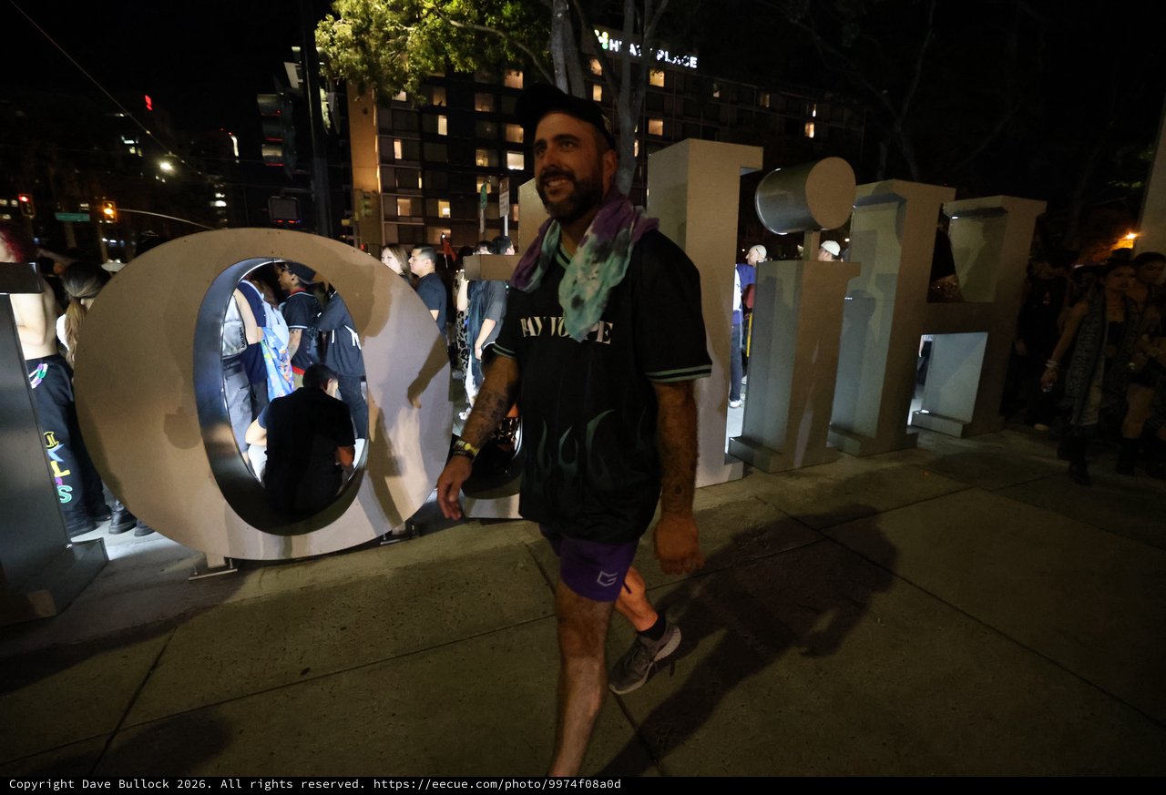 Festival Goer Poses at Wobbleland Sign at Night